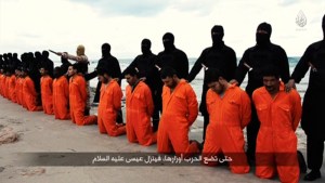 Still image from video shows men purported to be Egyptian Christians held captive by the Islamic State kneeling in front of armed men along a beach said to be near Tripoli